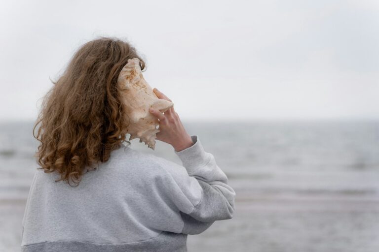 Woman listening to large seashell.
