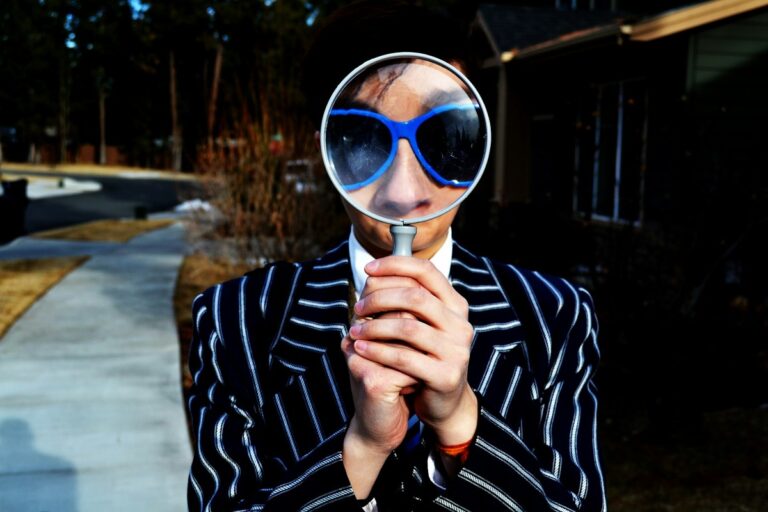 Woman holds magnifying glass.