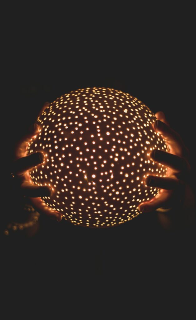 Hands holding soft lit sphere.